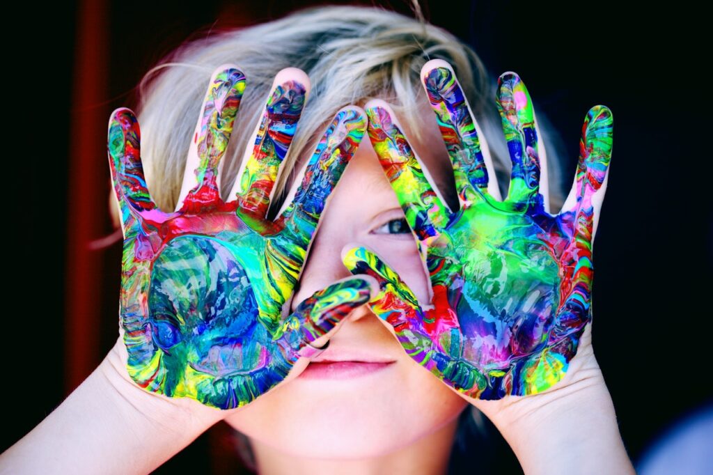 young boy with paint on hands